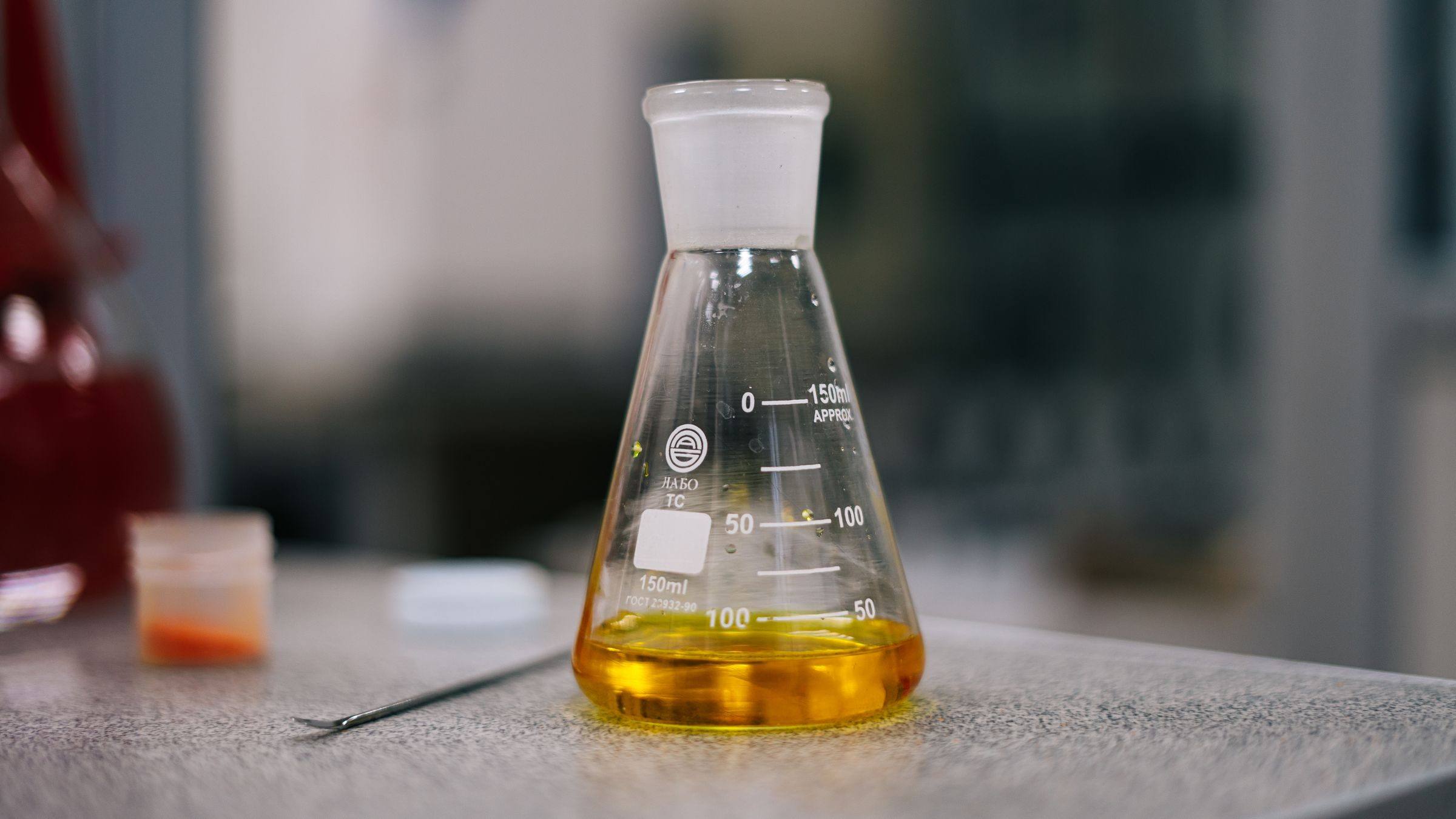 Sample of clean amber oil in a laboratory flask