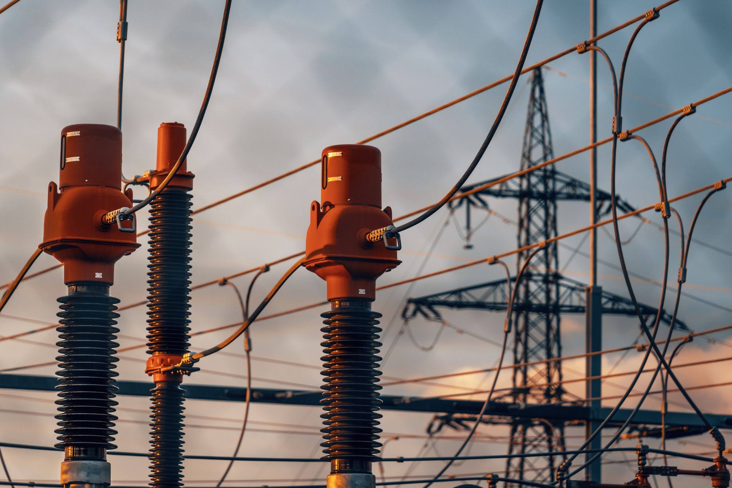 Oil-filled instrument transformers at a substation at sunset